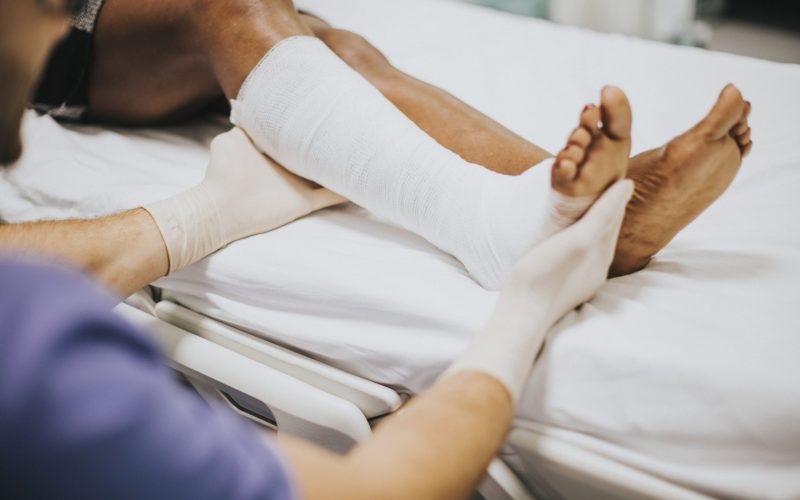 doctor-helping-patient-with-fractured-leg