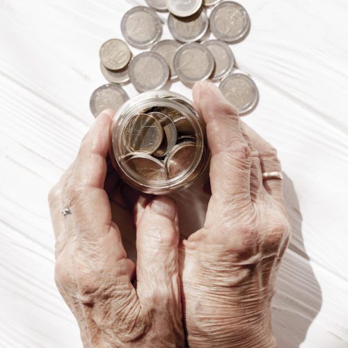 hands-holding-jar-filled-with-coins-top-view