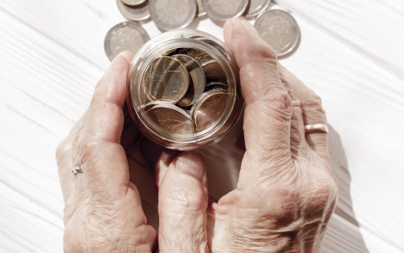 hands-holding-jar-filled-with-coins-top-view